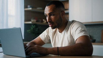 African ethnic male man at kitchen at home play online game bet losing betting bad result feel frustrated upset working problems business failure with laptop cryptocurrency crash mistake with computer