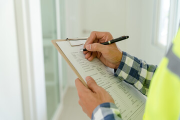 inspector or engineer is inspecting construction and quality assurance new house using a checklist....