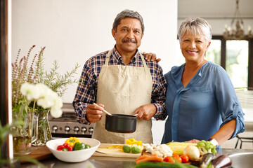 Their kitchen is seasoned with love. a happy senior couple cooking a healthy meal together at home.