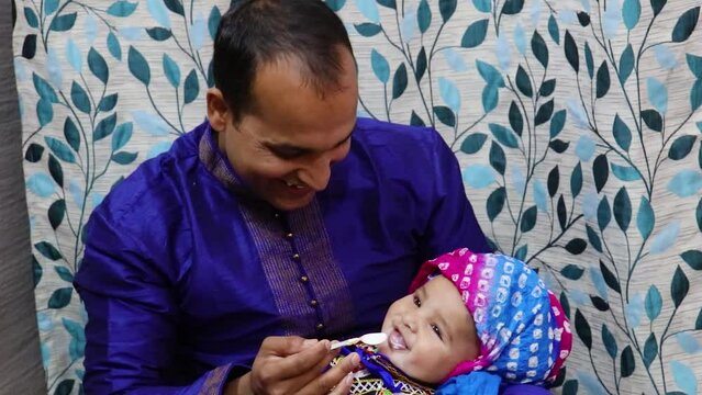 father holding baby boy at annaprashana occasion and indian traditional food served at banana leaf