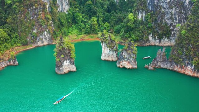 Three limestone rocks Three Brothers at Cheow Lan Lake, Khao Sok National Park, Surat Thani Province, South of Thailand. Aerial view 4K.