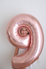 criança feliz com balão de aniversário numero nove 