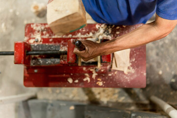 nadir shot hands of latino man carving a hole with his hands a wooden bull