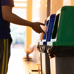 Young Asian men dump cans or plastic bottles in sorting bins for recycling, Garbage sorting and disposal, Environmental Love Project.