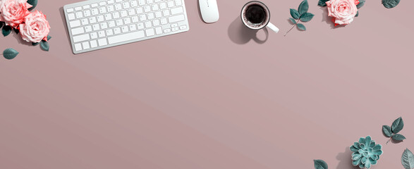 Computer keyboard and a mouse with pink roses - flat lay