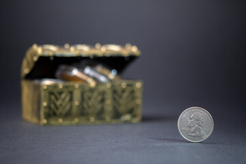 Quarter dollar coin on dark background. Saving and investing money for the future. Dollar treasury box