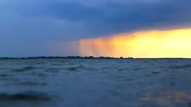 Rain falls over water for a time lapse.