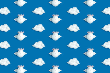 Easter flatlay pattern of angels and clouds on blue background. Decorated Easter eggs.