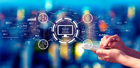 Fintech theme with person using a smartphone in a city at night