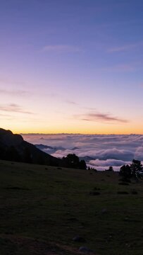 Coll de Pal, Bergued&agrave;, Girona, Spain. August 2022. Watch the breathtaking sunrise over the mountains as a sea of clouds ebbs and flows, creating a stunning splash-like effect against the peaks.