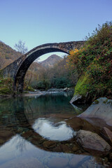 Fototapeta na wymiar medieval arch bridge in autumn in the mountains of georgia