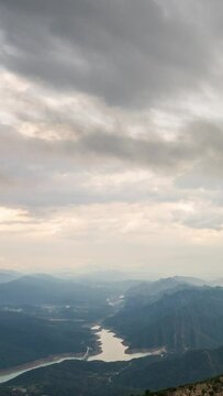 Berga, Catalunya, Spain. August 2022. Summer sunset at the viewpoint of La Baells reservoir: moving clouds create a spectacle of light and shadow among the mountains.