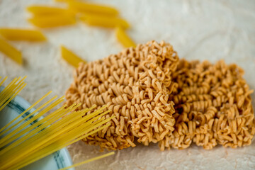 dried Instant noodles on white mulberry paper background. Instant noodles and pasta are wheat flour products call junk convenience food. Chinese and Japanese oriental noodle.
