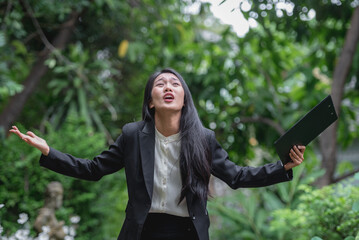Angry Cry emotional woman in black suit screaming in green garden background. young asian woman...