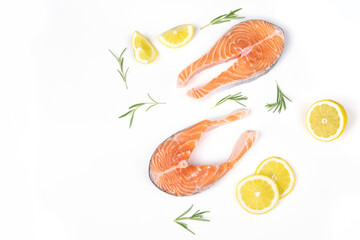 Fresh raw salmon slices with lemon and rosemary arranged on a white background. Healthy seafood food. Top view.