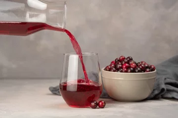 Tuinposter Glass with healthy cranberry juice on light background © Mihai