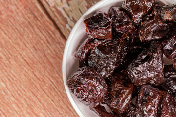 Ameixas sem caroço em tigela branca em cima de madeira rustica