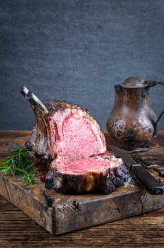 Traditional barbecue dry aged angus cote de boeuf with spice served as close-up on a rustic wooden board