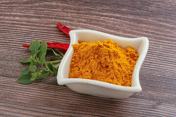 Yellow vibrant curcuma powder in the bowl