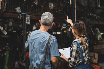 Asian woman customer talking with professional mechanic worker or workshop owner, client checking a maintenance job with garage automobile technician, business of car repair transportation service