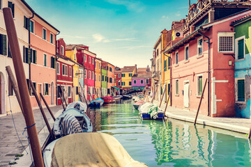 Burano, Italy with colorful painted houses along canal with boats