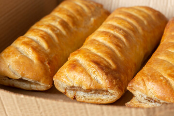 Sausage rolls in a cardboard takeaway tray. Sustainable biodegradable plastic free recycling packaging concept