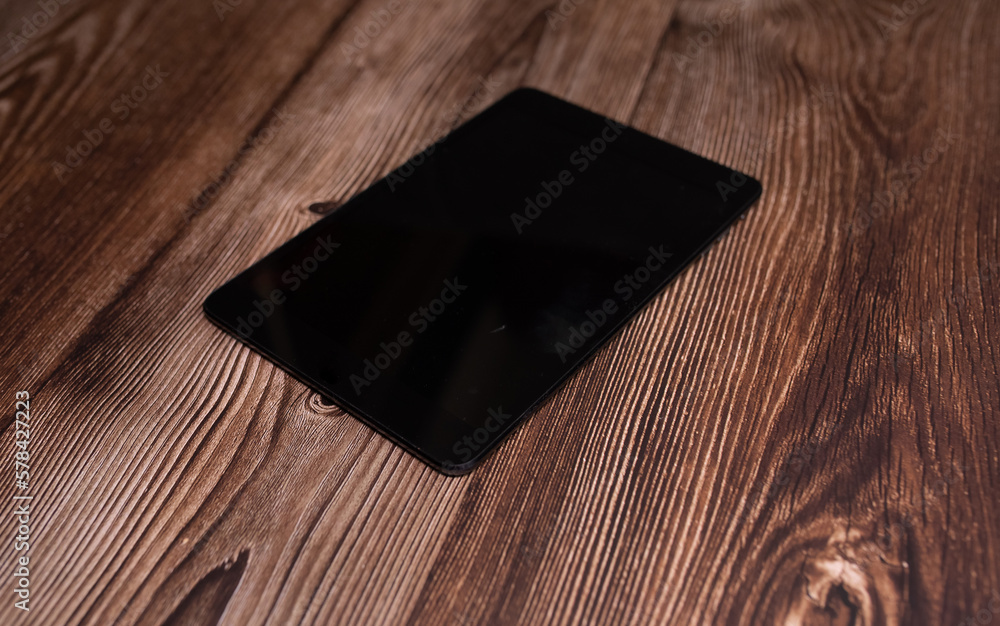 Poster digital tablet computer with isolated screen with clipping path on wooden background.