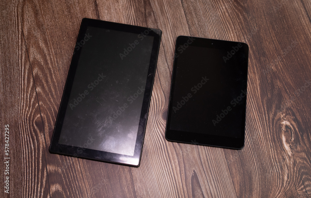 Poster digital tablet computer with isolated screen with clipping path on wooden background.