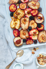 Baked apples, pears and plums with almonds, nuts and honey. Delicious and healthy dessert. Top view.