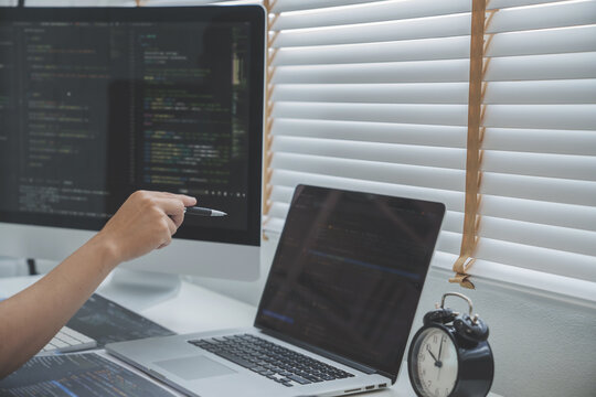 Programming developing software application. programmer writing program code with two monitors and working hacker on a new software