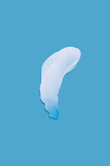 Cosmetic smear of cream texture on a blue background.