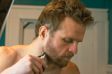 Obraz premium Man cursing his beard hair off, transformation theme, new year new me