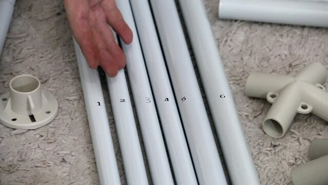 A man demonstrates the details of the construction for an awning. Assembly of a garden awning. Close-up.