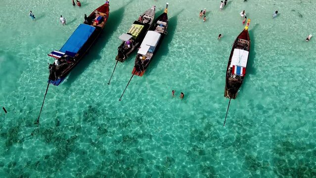 PHI PHI DON, THAILAND - DECEMBER 24, 2019: Aerial view of long tail boats and tourists visting Monkey Beach