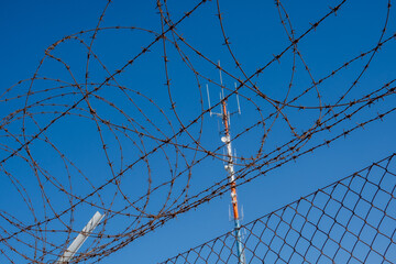 Barbed wire against blue cloudless sky