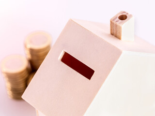 Closeup of a wooden piggy bank in the shape of a house.