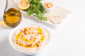 Hummus in a plate with chickpeas, smoked paprika, olive oil and pita. Vegetarian food.