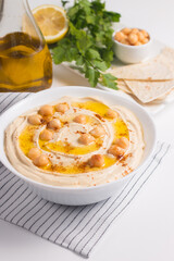 Hummus in a plate with chickpeas, smoked paprika, olive oil and pita. Vegetarian food.