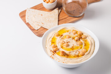 Hummus in a plate with chickpeas, smoked paprika, olive oil and pita. Vegetarian food.
