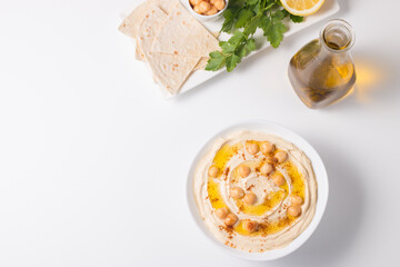 Hummus in a plate with chickpeas, smoked paprika, olive oil and pita. Vegetarian food.