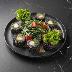 Vegan sushi rolls with black rice, avocado and sweet potato on a white plate. Vegan food concept.