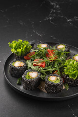 Vegan sushi rolls with black rice, avocado and sweet potato on a white plate. Vegan food concept.