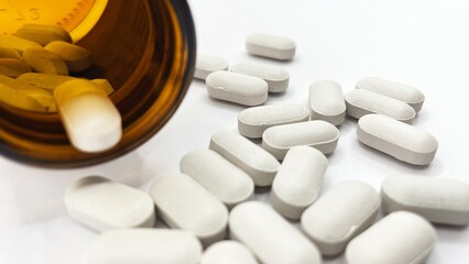 Close up of white round tablets on white background.