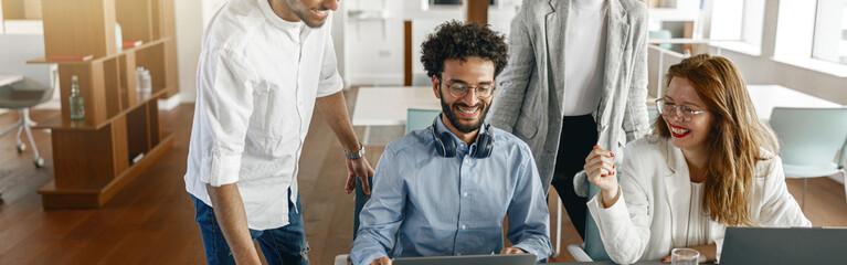 Happy coworkers cooperating and working together at office meeting, teamwork concept