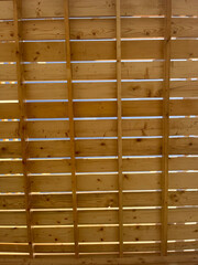 Closeup of plank roof through which you can see the blue sky