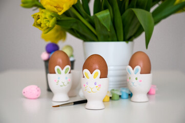 Easter greeting card with pastel paint,eggs in bunny holders etc