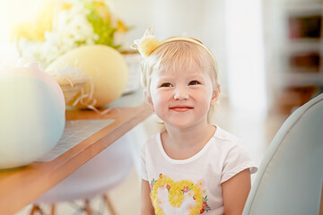 funny happy child girl with easter eggs. in the bright kitchen. Celebrating Easter at home