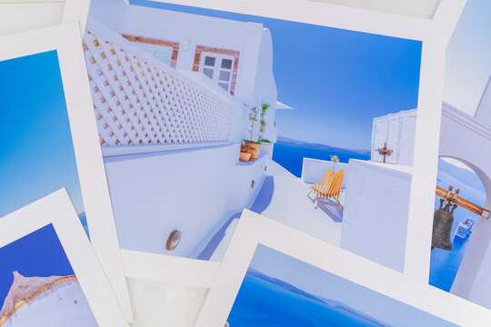 Lot de photos de voyage de différentes vues de Santorin posées sur une table blanche.	