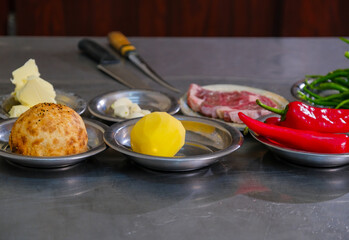 Potato, paprika, bread and meat dish preparation in restaurant kitchen.