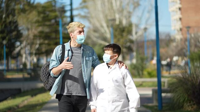 Father and son walking to school wearing face mask and a smock (an Argentinian white coat for public school)